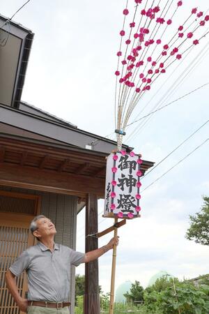 復元した「田楽灯籠」を見上げる光井栄一さん=新潟市西蒲区和納2