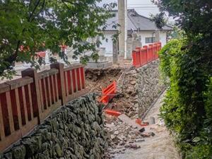 大雨で土がえぐれ欄干が崩れた宗像大社中津宮の境内=12日、福岡県宗像市(宗像市教育委員会提供)