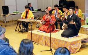 　演奏会で三線を弾く西原圭佑さん（右）＝７日、北京の日本大使館（共同）