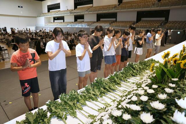 式典の前に献花する児童ら＝１日、長岡市のアオーレ長岡