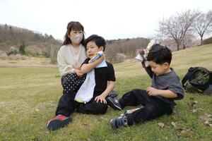 汗を拭きながら、水分補給する子どもたち=4月8日、新潟市秋葉区