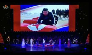 ロ朝芸術団の公演のスクリーンに投影された、北朝鮮の国旗に包まれたひつぎに向かう金正恩朝鮮労働党総書記。朝鮮中央テレビが30日に放映した(共同)