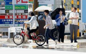 「逃げ水」が見られた静岡市駿河区を歩く人たち。気温41・4度を観測した=6日午後