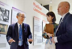 　４月３０日、米ニューヨークの国連本部で開催している原爆展で、スウェーデンの国会議員に説明する被団協事務局長の浜住治郎さん（左）（共同）