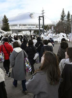 アイドルグループ「嵐」の公演が行われる札幌市の大和ハウスプレミストドームに向かう人たち＝１３日午後