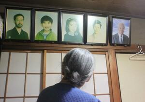 ２０１６年１２月、息子家族４人と夫の遺影を見つめる宮沢節子さん＝さいたま市