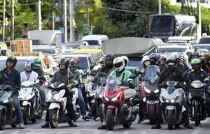 　夕方の通勤時間帯を迎えたバンコク中心部の交差点。渋滞が激しく、車の間をすり抜けるためにバイクを使う人も多い＝２０２６年５月（撮影・浮ケ谷泰、共同）