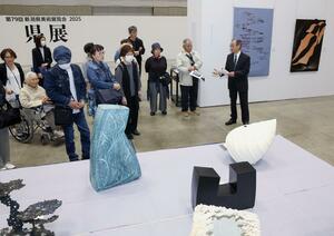 県展委員の解説を聞きながら作品を鑑賞する来場者=24日、新潟市中央区万代島