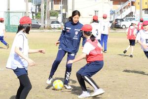 阪之上小学校の児童とプレーするアルビレックス新潟レディースの田中聖愛選手ら=長岡市今朝白1