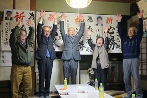 阿賀町議選でトップで初当選し家族や支持者と万歳する森満さん(中央)=4月20日、阿賀町津川