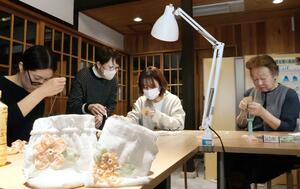 桜のバテンレースをあしらった小物を制作する参加者ら＝３月３０日、上越市大町５の旧今井染物屋