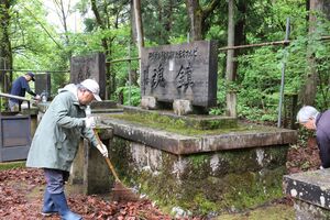 「ガ島・ビルマ方面戦没者慰霊碑」を清掃する保存会の会員ら=5月1日、長岡市西片貝町