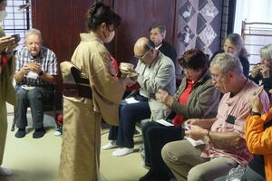 村上市大毎で開いた茶話会。一行は、たくさんの住民から歓迎を受けた