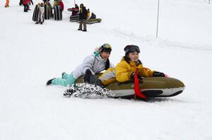 まつのやま学園アウトドア部とエアボードを楽しむ湘南学園小の5年生=十日町市松之山天水島