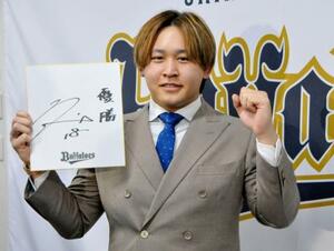 　契約更改を終え、来季の目標を書いた色紙を手にポーズをとるオリックスの宮城＝１８日、大阪市