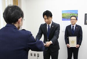 特殊詐欺等被害防止マイスター「匠」の認定証を受け取る齋藤俊広副支店長(中央)=阿賀野市中央町1