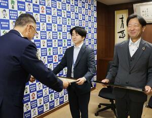 感謝状を受け取った第四北越銀行古町支店の帷子一支店長（右）と行員の松山昂弘さん（中央）＝新潟市中央区寄居町の新潟中央署