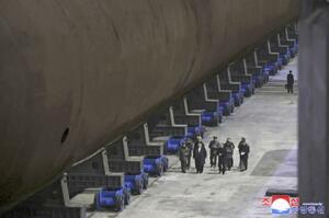 潜水艦の船底部分を視察する北朝鮮の金正恩朝鮮労働党総書記(手前左から2人目)(朝鮮中央通信=共同)