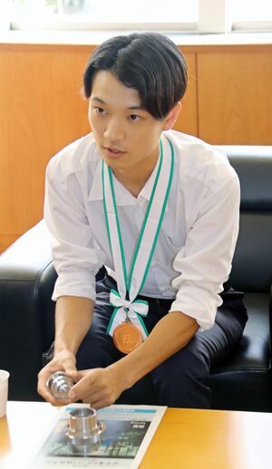 旋盤の競技を紹介し、大会を振り返る五十嵐諒哉さん=三条市役所