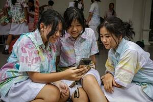　友人とスマートフォンでＴｉｋＴｏｋを見る１４歳の少女（左）＝２７日、インドネシア・ジョクジャカルタ（ゲッティ＝共同）