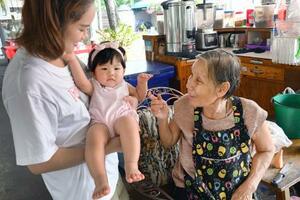 タイの首都バンコクの食堂であやされるタイ人家族の子ども=11月(共同)