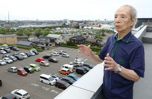 新潟日報社黒埼本社の屋上から、かつて建設作業をした山田島飛行場の跡地を眺める五十嵐文夫さん=新潟市西区