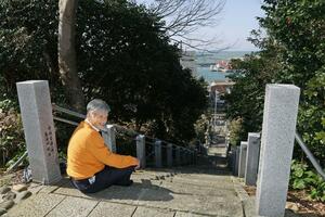 「神社仏閣を散策してほしい」と語る三上徹人さん。高台からは日本海や夕日を望むことができる=3月中旬、長岡市寺泊二ノ関の白山媛神社