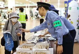 自転車の鍵かけなどを呼びかける新潟西署員=9日、新潟市西区小新5