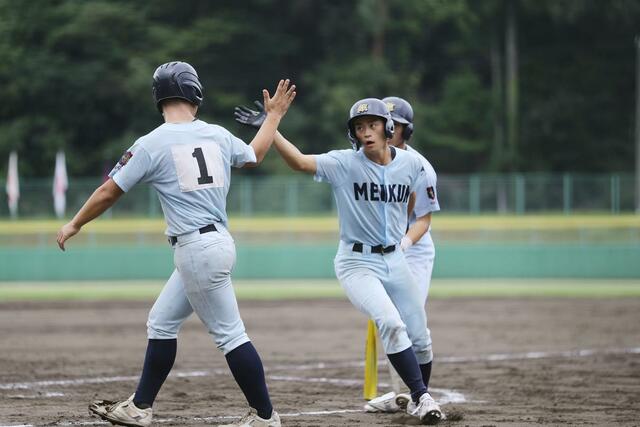 ４回無死一塁　２点本塁打を放ち、仲間とハイタッチする新潟明訓の主将髙橋隆太＝９月１１日、新発田市五十公野公園野球場