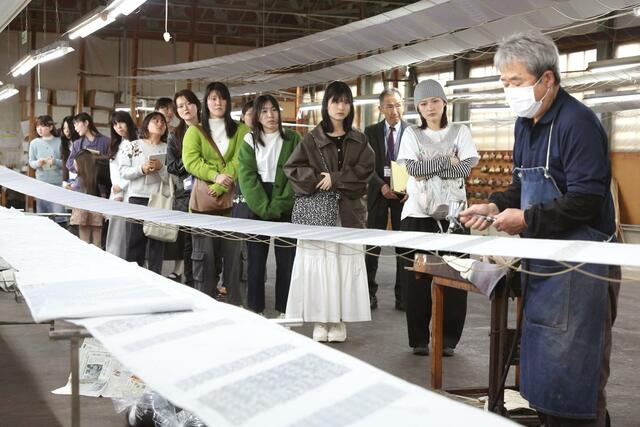 友禅の技法を見学する学生＝２２日、十日町市明石町の青柳
