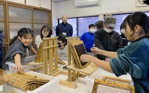 住民に教えてもらいながら、慎重に判のり作りに取り組む児童ら=1月30日、佐渡市沢崎