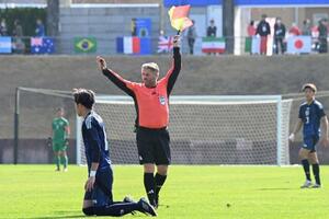 サッカー男子の日本―オーストラリア戦で、笛だけでなく、旗も使うサッカーの主審=福島県Jヴィレッジ