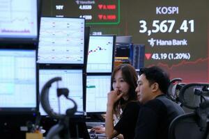 韓国・ハナ銀行のディーリングルームで株価指数を見つめるトレーダーら=13日・ソウル(AP=共同)