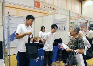 フラーのブースで、個人投資家らに企業概要などを説明する担当者=17日、新潟市中央区