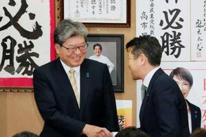 　東京２４区で当選を決め笑顔を見せる萩生田光一氏（左）＝８日午後１１時３１分、東京都八王子市