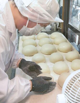 手作業で丁寧に丸められる鏡餅=28日、新潟市中央区の笹川餅屋