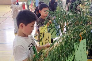 標語を書いた短冊を結び付ける子どもたち=新発田市黒岩