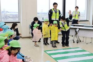 手を上げて横断歩道を渡る練習をする園児ら＝７日、新潟市西区小新