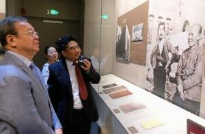 内山完造と魯迅が写った写真(右)を眺める上海市人民対外友好協会の関係者ら=19日、中国上海市(共同)