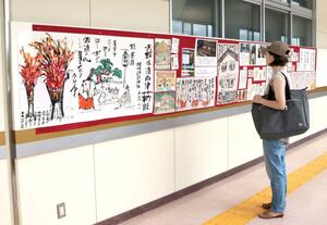 旅行者それぞれの印象に残った風景などが、文章とともに描かれている絵手紙の展示会場=佐渡市両津湊