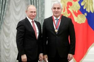 　モスクワのクレムリンでロシアのプーチン大統領（左）から勲章を受章したカムボロフ氏＝２０１８年１１月（タス＝共同）