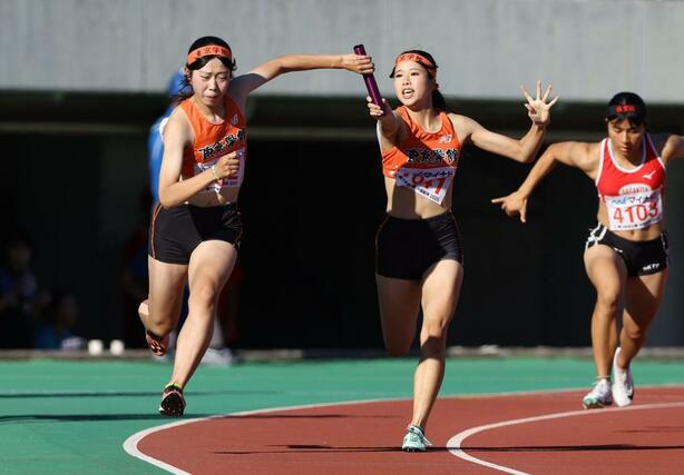 女子４００メートルリレー　予選通過した東京学館。１走の高橋和夏葉（右）から２走の本田悠里（左）にバトンをつなぐ＝広島市