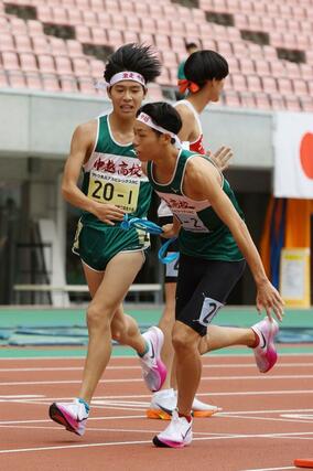 男子 中越の1区佐藤悠斗(左)が区間賞の走りで2区村田大翔にタスキを渡す=新潟市中央区