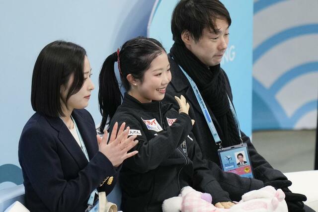 女子ＳＰの得点を確認し、笑顔の中井亜美（中央）。奥は中庭健介コーチ＝北京（共同）