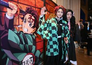 中国上海市の映画館で、劇場版「鬼滅の刃」の上映前に記念撮影するコスプレ姿のファン=13日(共同)