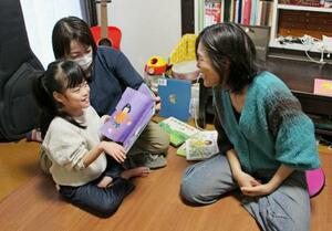 障害に対応したゲーム体験会を振り返る、いぶきさん(左手前)と母親(右)=3月、東京都内