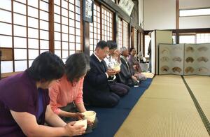 念相寺のお堂で本格的な茶を楽しむ参加者=出雲崎町尼瀬