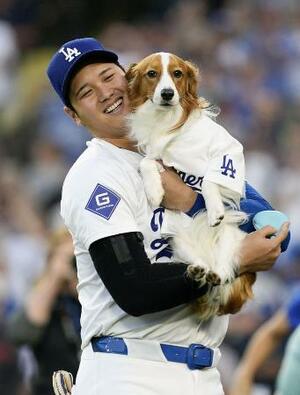 昨年8月、米大リーグのオリオールズ戦で「始球式」を行った愛犬デコピンと笑顔のドジャース・大谷翔平=ロサンゼルス