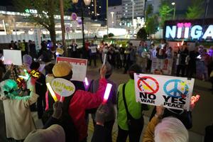 プラカードやペンライトを手にイラン攻撃や憲法改正への反対を訴える参加者＝１９日、新潟市中央区