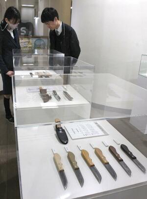 企業の技術を生かしたこだわりのアウトドアナイフが並ぶ企画展=三条市下須頃